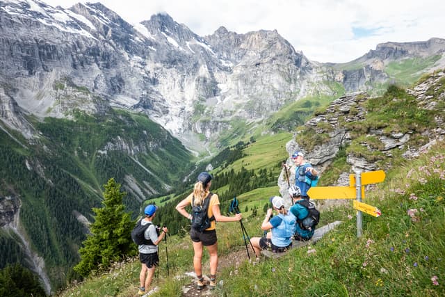 A group of trail runners in the Bernese Oberland at some sign posts.