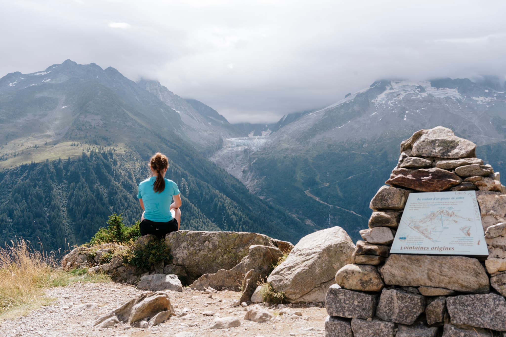 Runner sits and looks at view of glacier and mountains