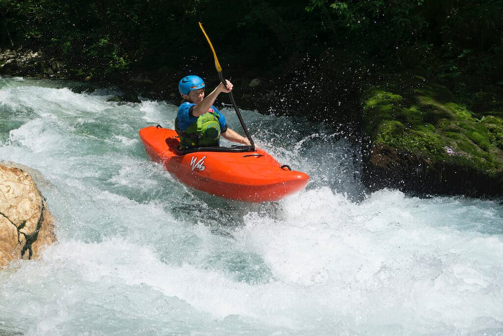Becki Penrose in an orange kayak at River Soca, Slovenia