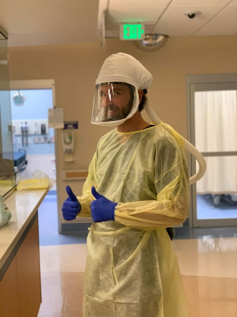 Dr John Anderson with surgery outfit including blue gloves in the hospital