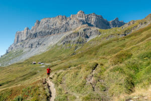 Trail runner on a single track with Refuge du Moëde Anterne at the back