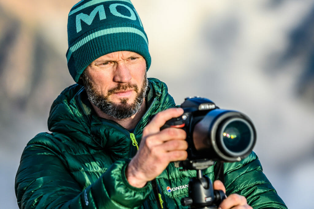 Mark Brightwell with green jacket and bonnet behind the lens