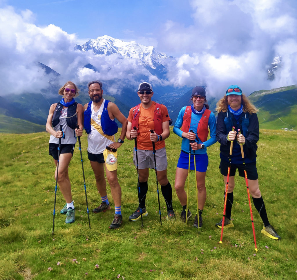 Five trail runners stop and posed with the Mont Blanc Massif at the back