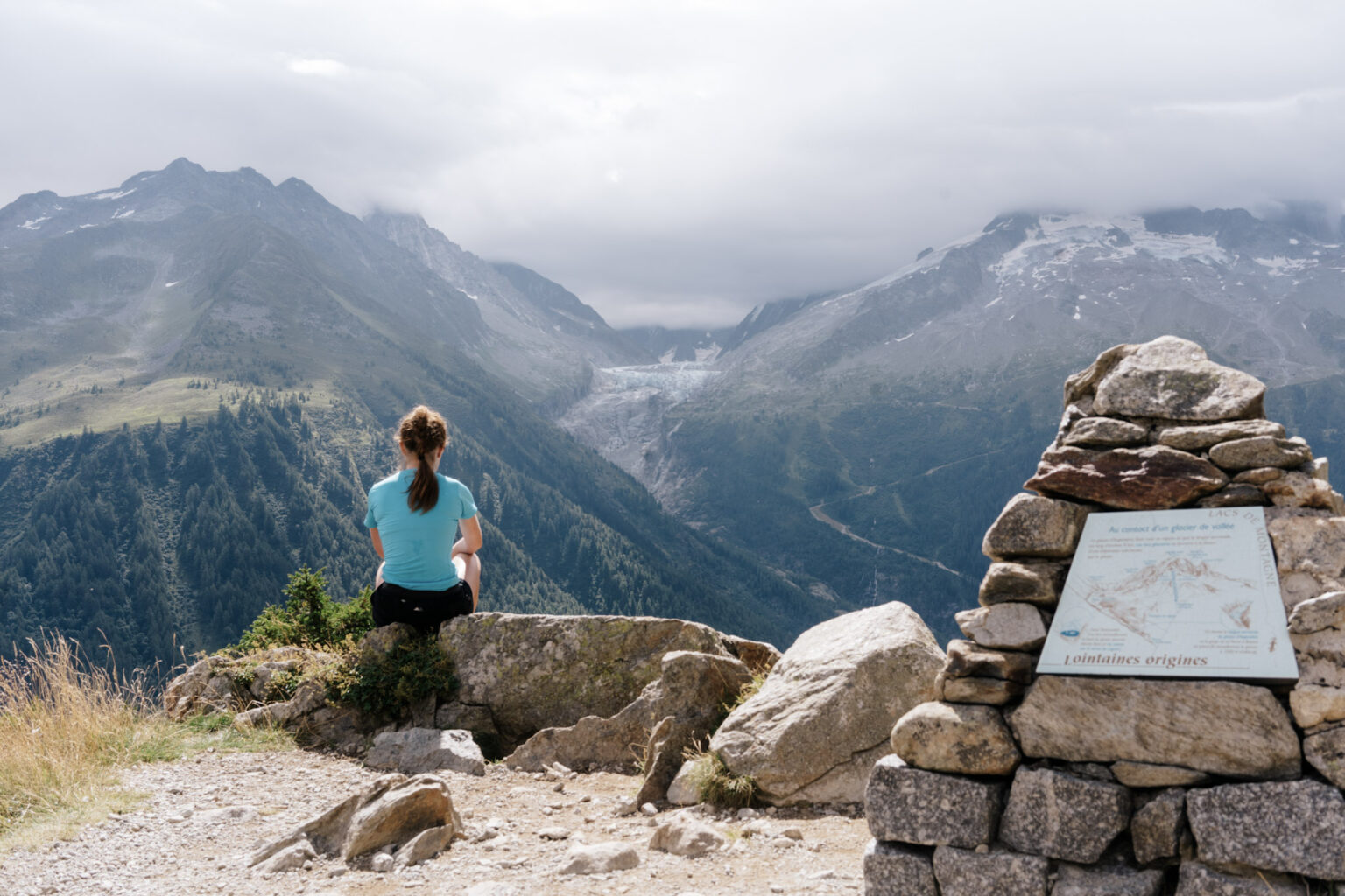 Runner sits and looks at view of glacier and mountains
