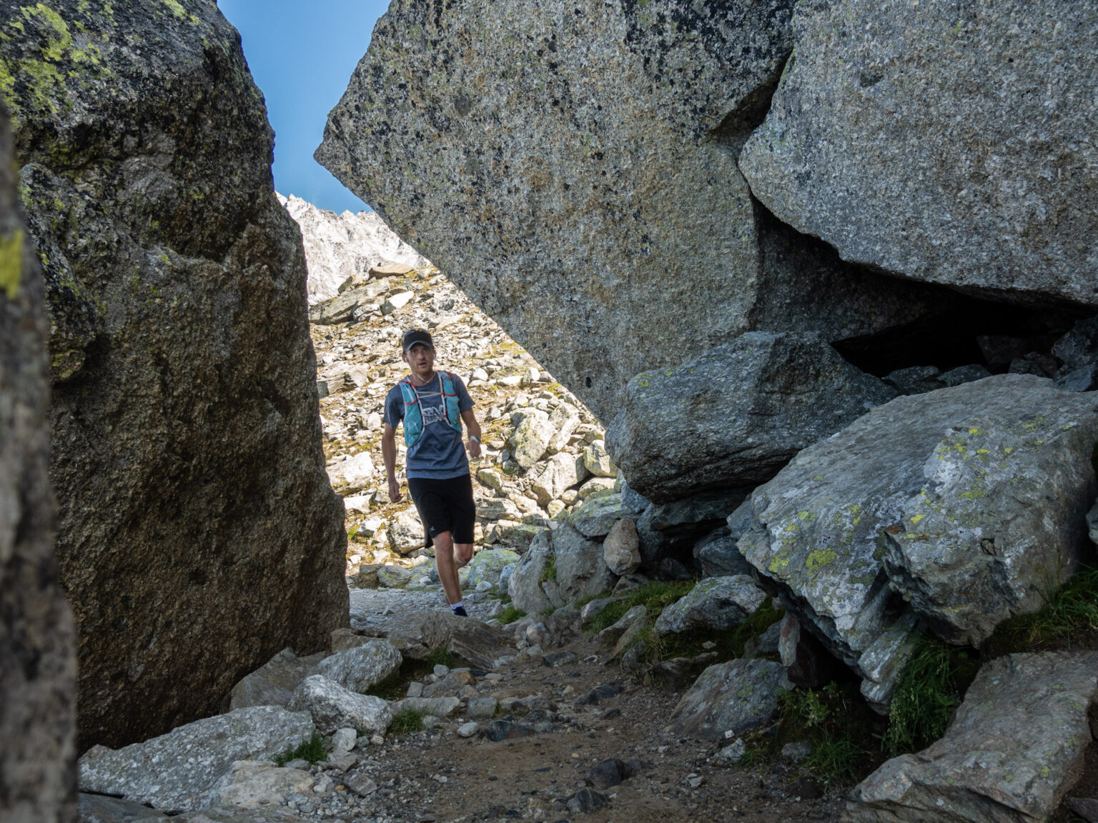 runner on rock trails with large boulders either side