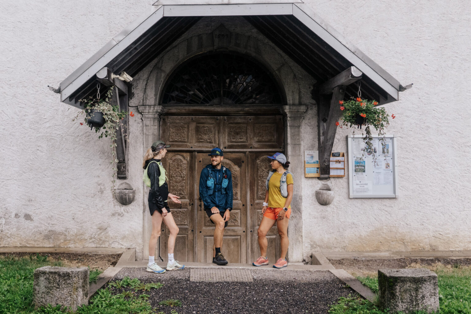 3 runners stood outside old church