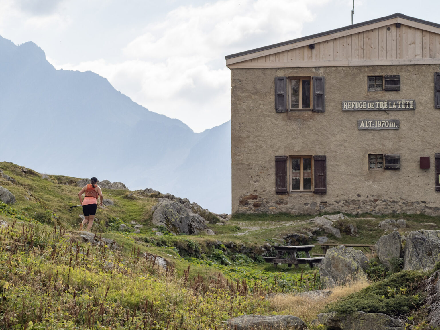 runner approaches mountain hut