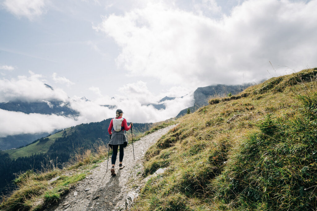 hiker with poles on a grassy hillside