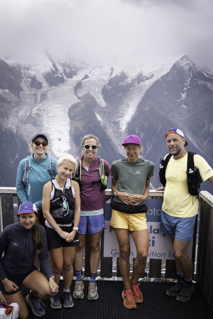 a group of six runners posed in front of Chamonix mountains