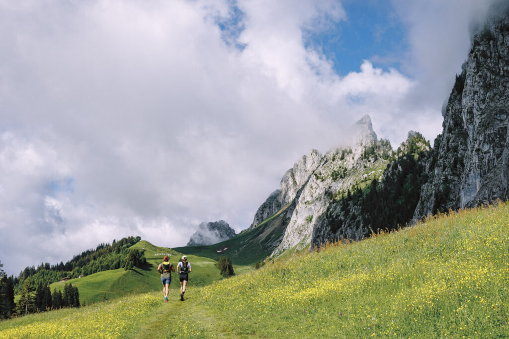 two runners in a green pasture Champery Switzerland