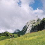 two runners in a green pasture Champery Switzerland