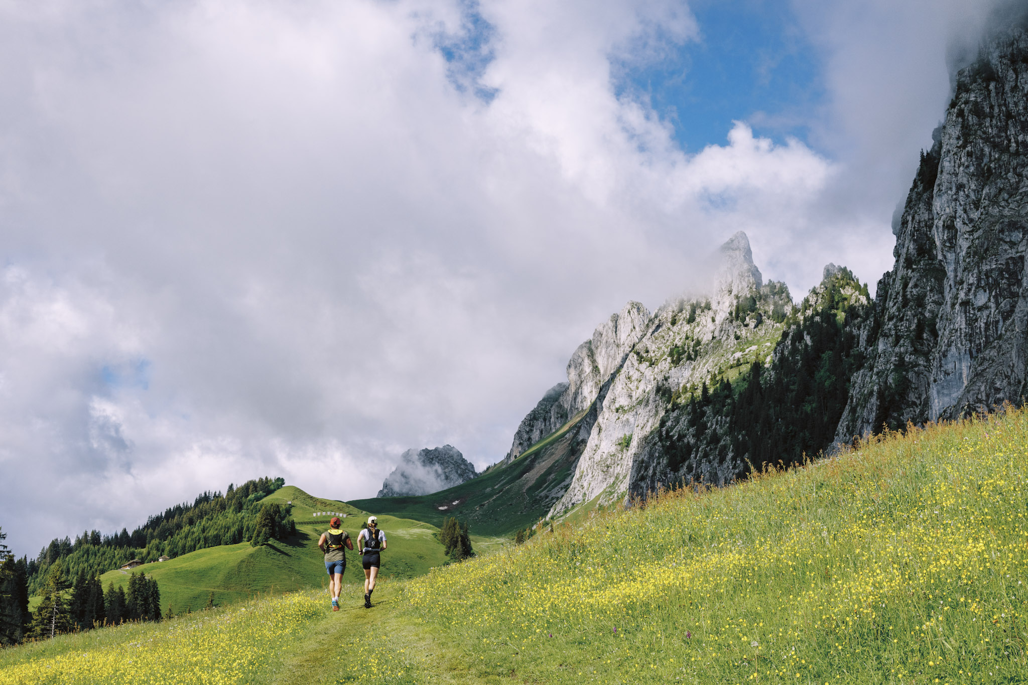 two runners in a green pasture Champery Switzerland