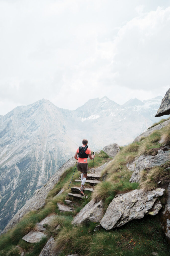 runner going up grassy steps in the mountains